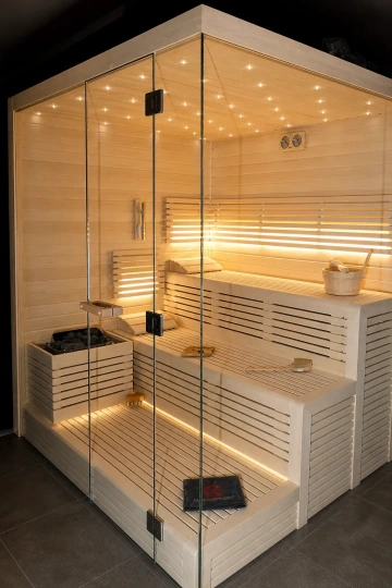 Moderní prosklená sauna z osiky s LED hvězdným nebem, podsvícenými lavicemi a minimalistickým interiérem pro komfortní domácí saunování