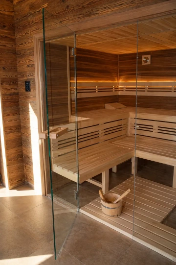 Prosklená finská sauna s prosklenou čelní stěnou v čirém provedení.